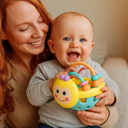 Baby Play Ball with Soft Textured Elements, Movable Rings and Bright Colors in Yellow or Pink